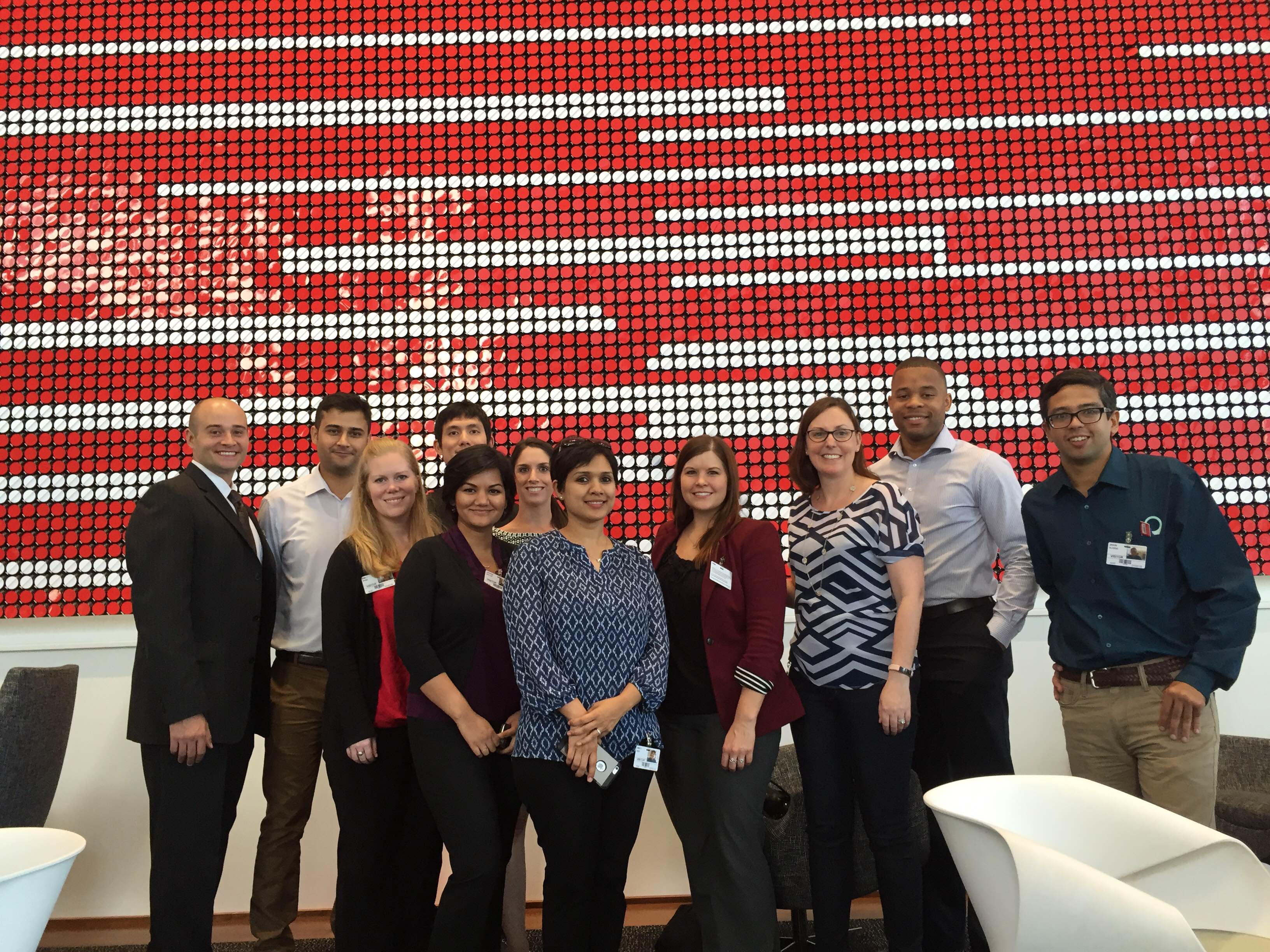 Georgia Tech MBA Net Impact chapter members with Georgia Tech MBA alumna and Coca-Cola employee Ashley Vanderpoel, in front of Coca-Cola's flip-disk wall