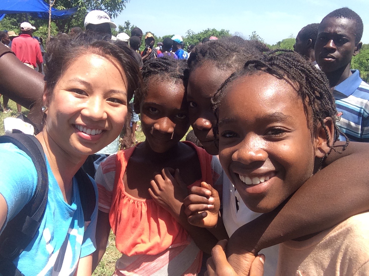 Linnette poses with children in Haiti.